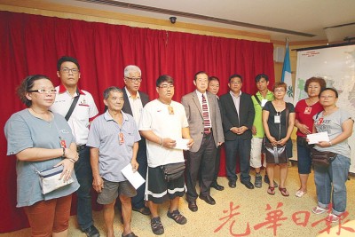 林冠英(左6)颁发援助金予3户受灾家庭。左4为彭文宝、左7为林峰成和黄汉伟。