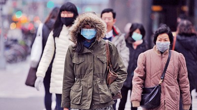 台北市民一身厚重衣物迎接低温的上班日。(中央社照片)