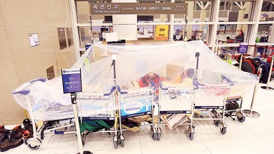 韩国济州机场滞留旅客席地而睡。(法新社照片)