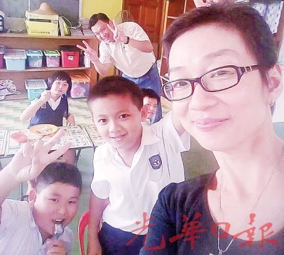 阮小花于办事之场地,和孩子们亲切合照。