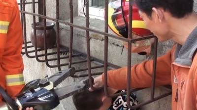 消防员使用工具撬开防盗窗,受男童逃脱。