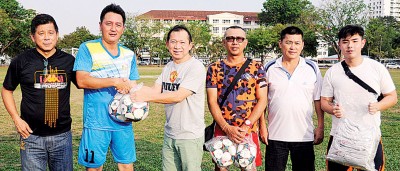 彭杯竞赛顾问林清吉(左3)移交赛会衣服和皮球给大马子民同少年联队代表。