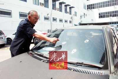 阿都嘉化指出警方击中的弹孔。