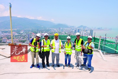每当Alam Langkawi董事孙荣贵(倍受)陪伴下,本报采访阵容:曾国权(左起)、林松荣、李秋缘、郑国良以及骆炜芬,同在光大顶楼的高空走道下合影留念。