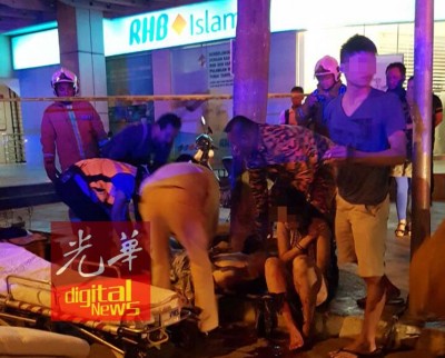 救护员准备把伤者抬上担架,送往医院。