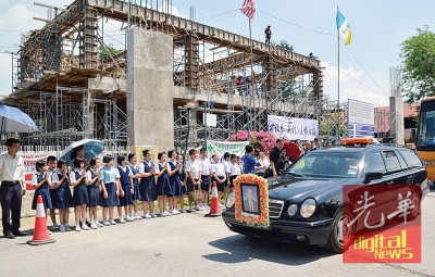 林兴镇校长的灵车在启新小学短暂停留,师生列队做最后敬礼,背景为如火如荼兴建中的启新礼堂。
