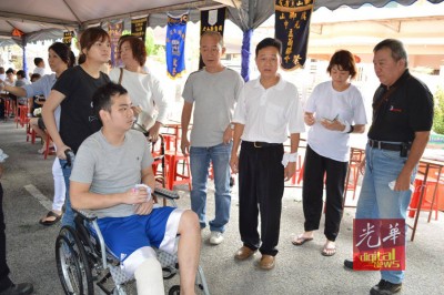 骆礼贤(坐轮椅者)负伤送好友最后一程,右3为黄勇溢。