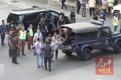 警官将死者遗体抬上警车,未雨绸缪送往太平间。