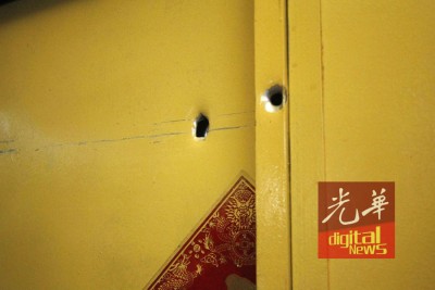 子弹贯穿铁门,留两处弹孔。