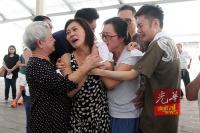 死者遗体焚化后,家属与亲友们抱在一起。