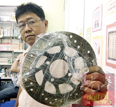 罗添寿展示着对方撞坏的摩托车煞车器。