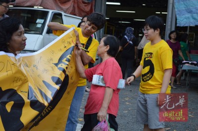 益美园巴刹民众在横幅上签名支持。