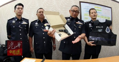颜天记(右起)同哈斯南亮警方起获的自发性手枪,和中枪警员当时通过在的免弹衣。