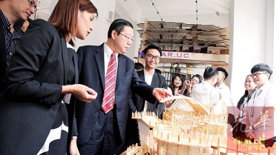 陈美佑(左起)陪同林冠英巡视学生建筑设计作品。