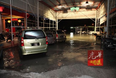 潮水淹没部分停车场,使得停在该处的轿车和摩托轮胎被浸泡在水中。