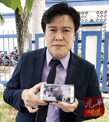 谢嘉平向媒体展示J座组屋升降机冒浓烟的视频。