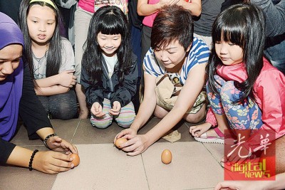 小孩子在现场体验立鸡蛋的乐趣!