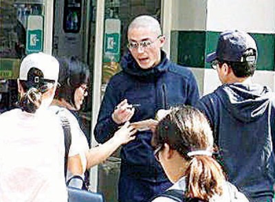 霍建华扬手示意粉丝别跟,而是按亲切为她们签名。