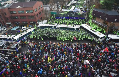 韩国民众周六游行逼近到距青瓦台仅200公尺处,警方以警车筑车墙戒备。(法新社照片)