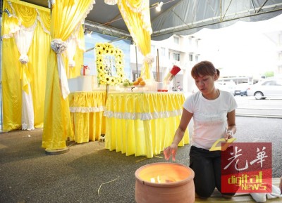 冯艾雯红正在眼眶地烧冥纸,万般无奈无法看到父亲最后一面。