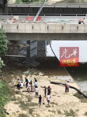死者亲友周四上午至事现场的河岸,啊死者进行招魂仪式。