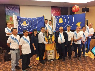 周昌江(右5)传递纪念铜钟给锺灵中学新加坡校友会会长范文斌(左4)。