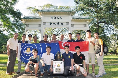 新加坡南洋理工大学锺灵学生与百年校庆纪念铜钟于前南洋大学大门前合影。