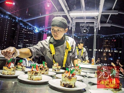 尽管在高空中,厨师仍一副处之泰然的规范,也饕客准备美味的美味。
