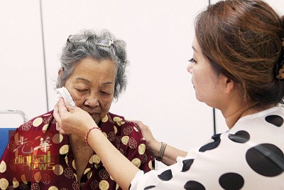 长女(右)啊母拭擦眼泪。