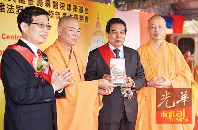 马来西亚华教总会总会长暨极乐寺慈善医院主席日恒长老赠送纪念品予卫生部副部长希尔米，右为极乐寺方丈贤观大和尚及左为筹委会主席拿督黄得轩。