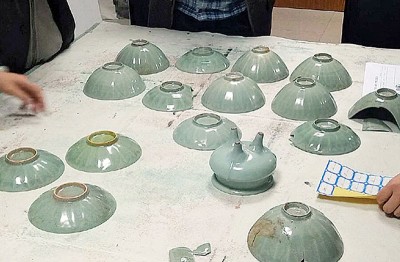 施工队共挖出的釜内8件瓷碗、7件瓷盘及1件瓷三足炉。