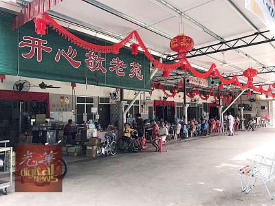 老人闲时在敬老苑前范围聊天。