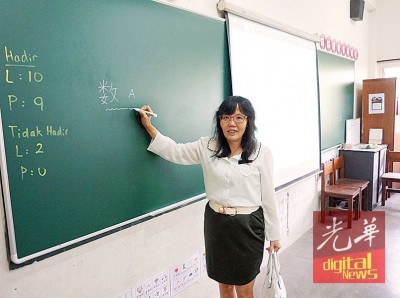 胡素彬介绍该校的电脑教学系统及环保黑板。