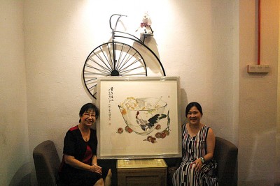 沈颖(右)的鸡公碗彩墨画,得到收藏家的赏识,左为槟水墨画协会会长翁丁健。