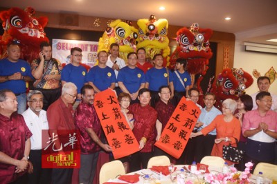 拿督方万春(台上前排右3)统领狮队前来贺年,给槟首长林冠英(台下右6)同曹观友(台下左6)对联“火箭报喜,喜爱上加以喜”。