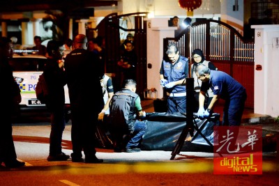 警方结束调查后,包裹死者的遗体准备送往槟城医院太平间。