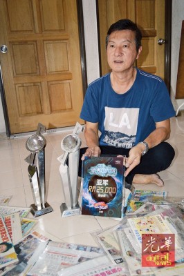 周振隆向媒体展示奕斌在本地赛事中获得亚军的奖座,欣慰孩子最后成功在国际赛夺冠。