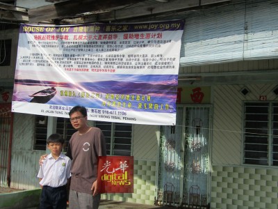 义工林传杰与顺洋在喜乐之家买下的板屋前合影,该板屋将进行装修。