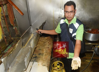 卫生局官员在其中一家食肆厨房内的灶台上抠出了一层厚厚的污垢及食物渣。