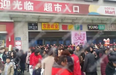 有民众在被查封的乐天玛特超市门外拍照。
