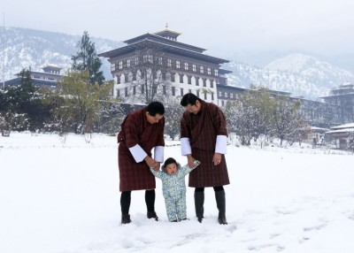 小王子(中)手牵着父王和祖父的手,在雪地上散步,场面温馨。