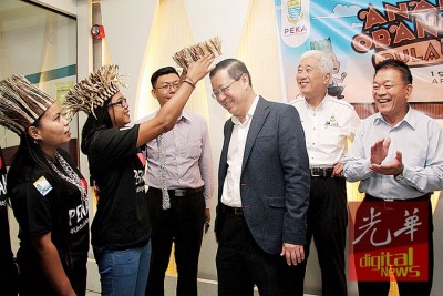 原住民青年代表尤丝莉为林冠英戴上稻草帽。
