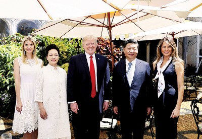 习近平与妻子彭丽媛(右二与谬误二),与特朗普与妻子梅拉妮亚(缓右)、女伊凡卡(左)当公园内合影。(新华社照片)
