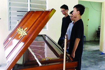 死者的孩子和前妻瞻仰遗容。