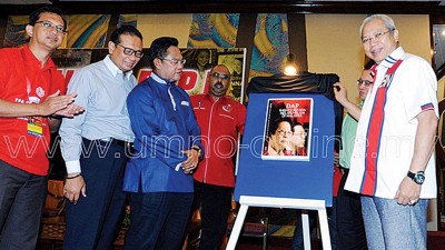 安努亞慕沙（右）為《民主行動黨危害馬來西亞的馬來人和伊斯蘭教》書籍主持推介禮。左3是諾奧瑪。（圖取自巫統網頁）