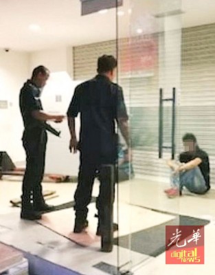 被误为窃贼的华裔男子一脸无奈坐在地上。
