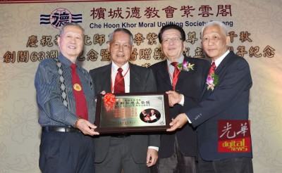 黄赐兴(右)给纪念牌匾给李斯仁(左),伴者为许春畴同周荣吉。