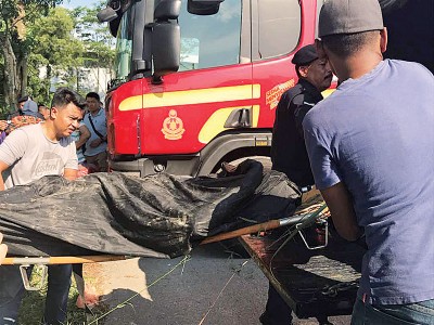 消拯员把死者遗体抬上警车,准备载往医院太平间。