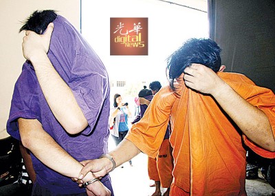 2号称男性嫌犯被押上法庭申请延扣时,因衣服遮脸避开摄影镜头。