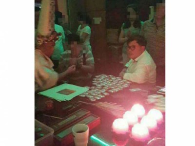 身穿白衣的张誉发正在向一名大伯爷乩童问事。